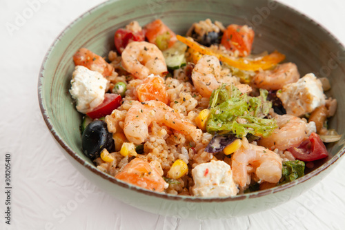 rice with salmon and shrimps, olives, feta, corn, lettuce, tomato, vegetable ingredients