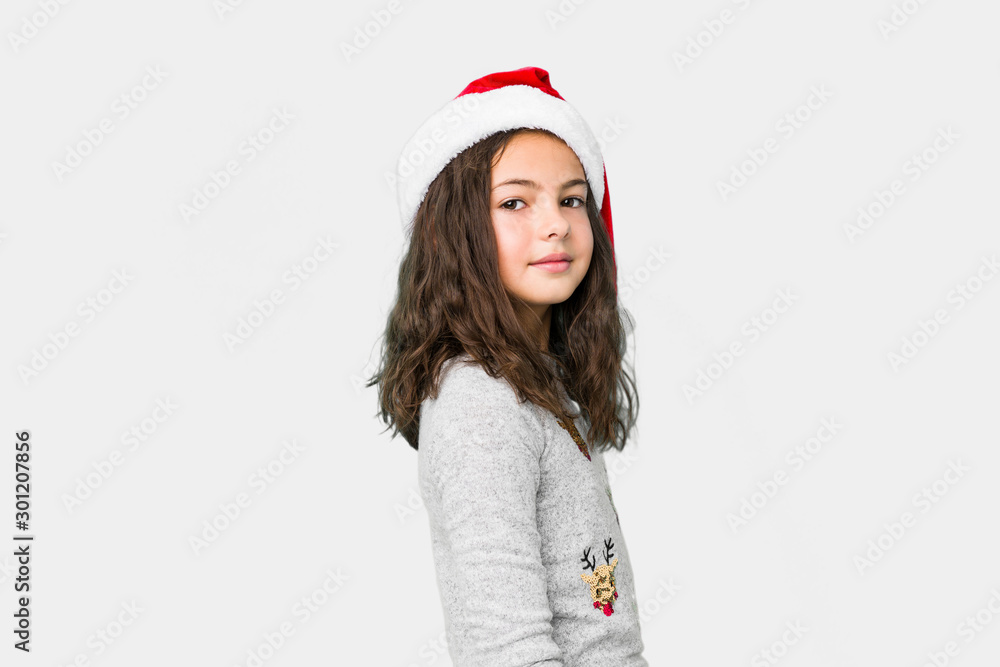 Little girl celebrating christmas day looks aside smiling, cheerful and pleasant. Little girl celebrating christmas day looks aside smiling, cheerful and pleasant.