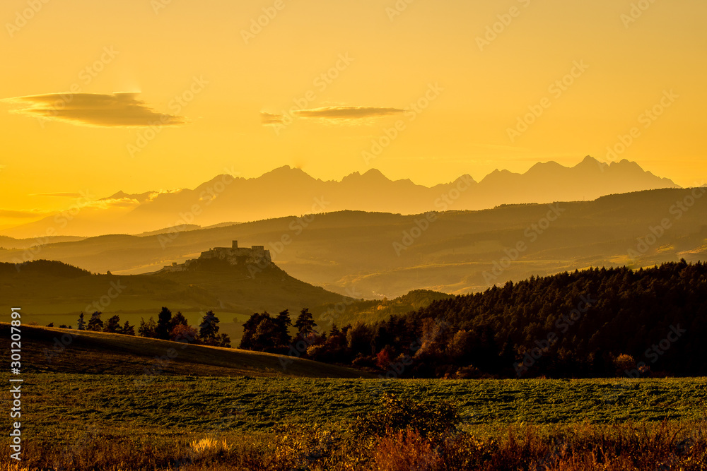 Sunset over the Spis Castle in backround with wonderful scenery of High Tatras Mountains, Slovakia