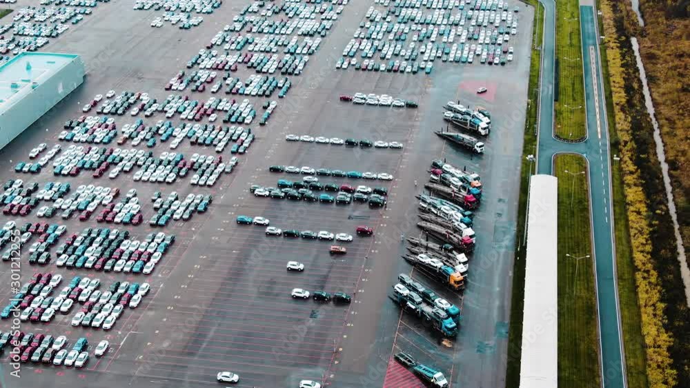 cars and transporting trucks stand on outdoor parking lot cars and transporting trucks stand on outdoor parking lot