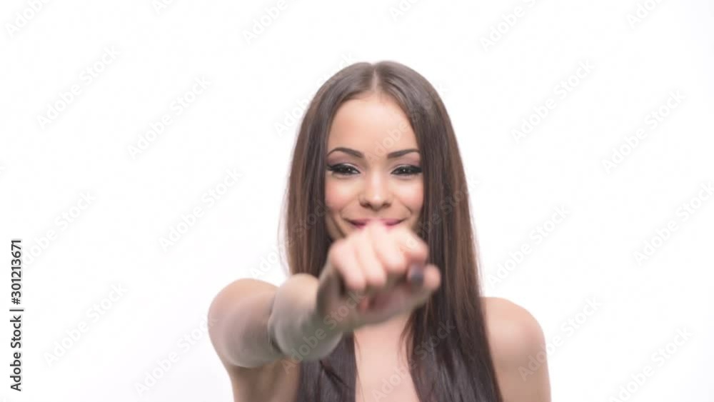 Charming young brunette beauty girl pointing finger at camera picking you isolated on white background. Charming young brunette beauty girl pointing finger at camera picking you isolated on white background.