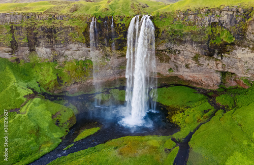 Waterfall Seljalandsfoss in Iceland. Beautiful Icelandic landscape during summer time. Golden Ring tourist route destination, iconic landmark in Iceland.