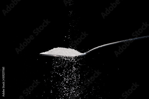 spoon of sugar on black background