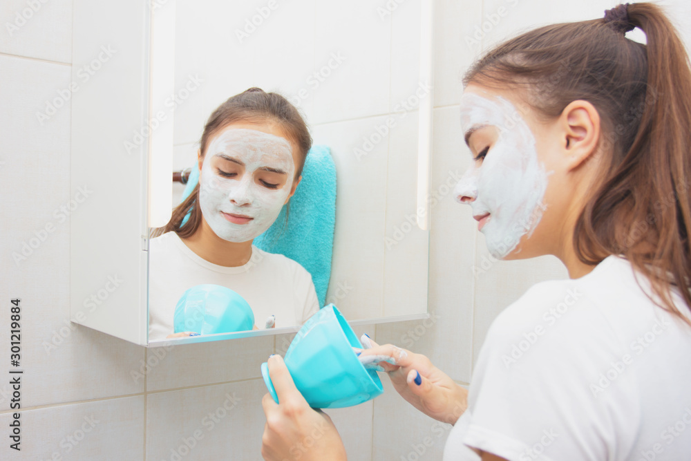 Fototapeta premium Health and beauty. Facial skin care. Young girl makes a moisturizing cleansing face mask