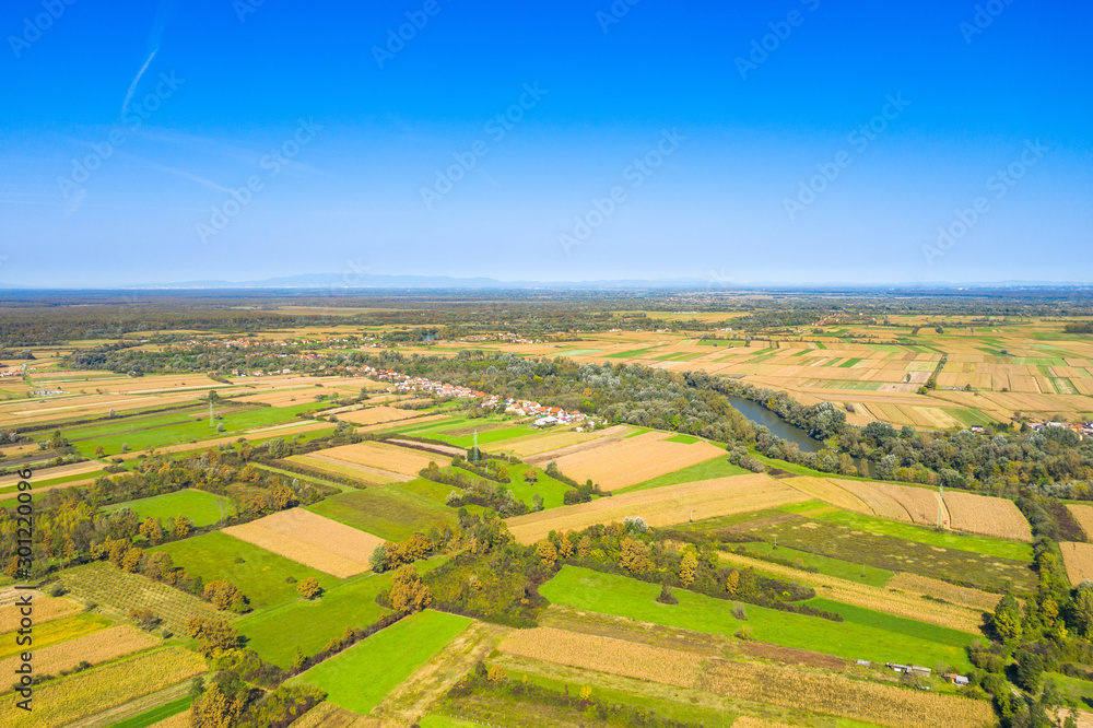 Beautiful countryside landscape in Croatia, near Sisak, Sava river meandering between agriculture fields, aerial shot from drone