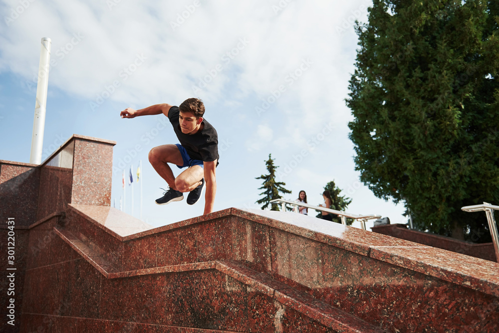Above the obstacle. Young sports man doing parkour in the city at sunny daytime Above the obstacle. Young sports man doing parkour in the city at sunny daytime