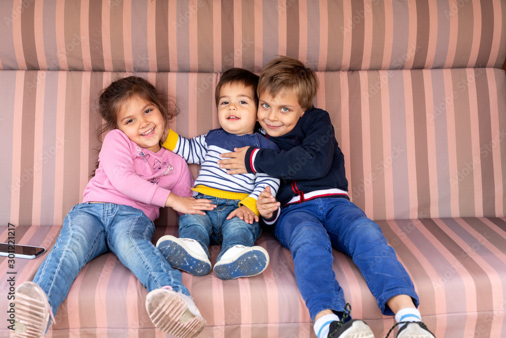 © Vladimir Godnik/Westend61 - Portrait of three siblings sitting side by side