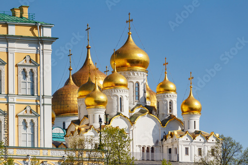 Golden domes of Cathedral of the Annunciation of Moscow Kremlin in sunlight against blue sky at spring morning. Architecture of Moscow Kremlin