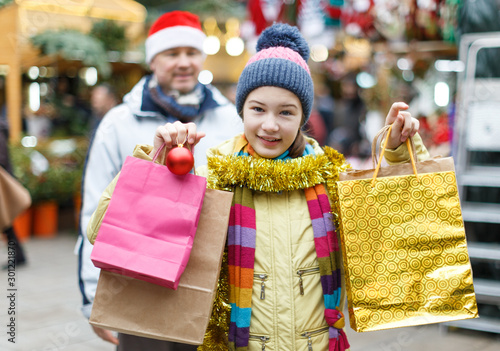 Smiling girl with father holding shopping bags