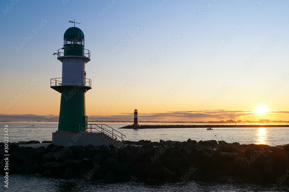 The two lighthouses on the breakwater in Warnemünde during sunrise