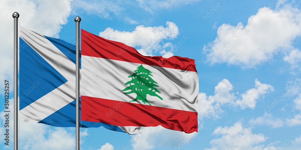 Scotland and Lebanon flag waving in the wind against white cloudy blue sky together. Diplomacy concept, international relations.