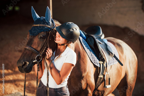 Ready for the ride. Horsewoman in uniform and black protective helmet with her horse © standret