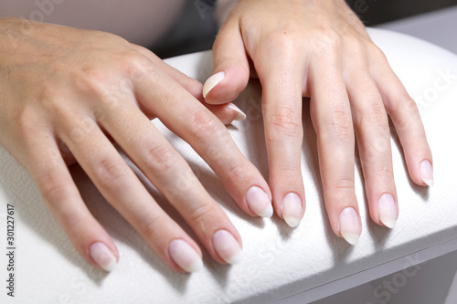 Hands of a client with manicure before applying a gel base close-up.
