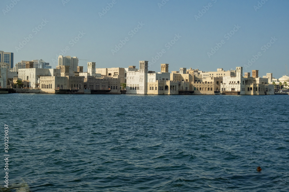 View from the marina to the blue water canal in the city center and buildings on the opposite bank. Dubai Bay in Deira.