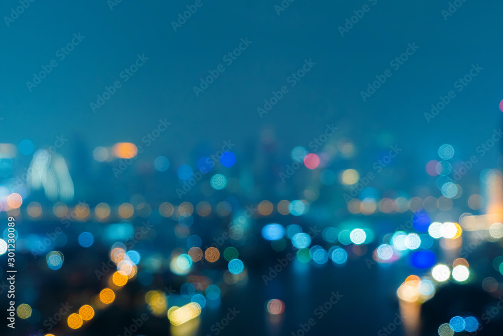 Bokeh background of skyscraper buildings in downtown. Urban city with lights, Blurry photo at night time.  illuminated Cityscape - obrazy, fototapety, plakaty 