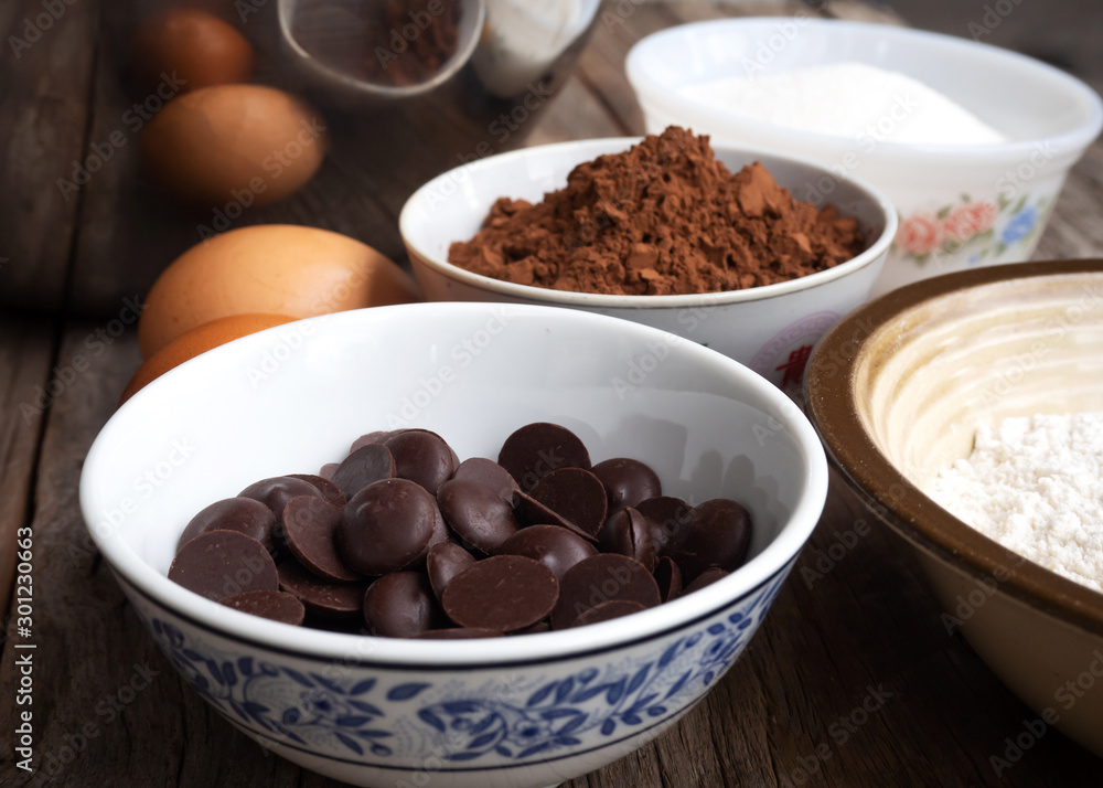 Closeup dark chocolate in small bowl. Brownies ingredients on wooden table. Closeup dark chocolate in small bowl. Brownies ingredients on wooden table.