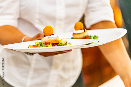 Modern food stylist decorating meal for presentation in restaurant. Closeup of food stylish. Restaurant serving