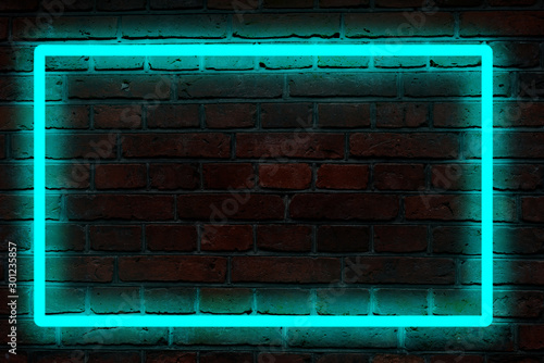 blue neon light on a brick wall at night