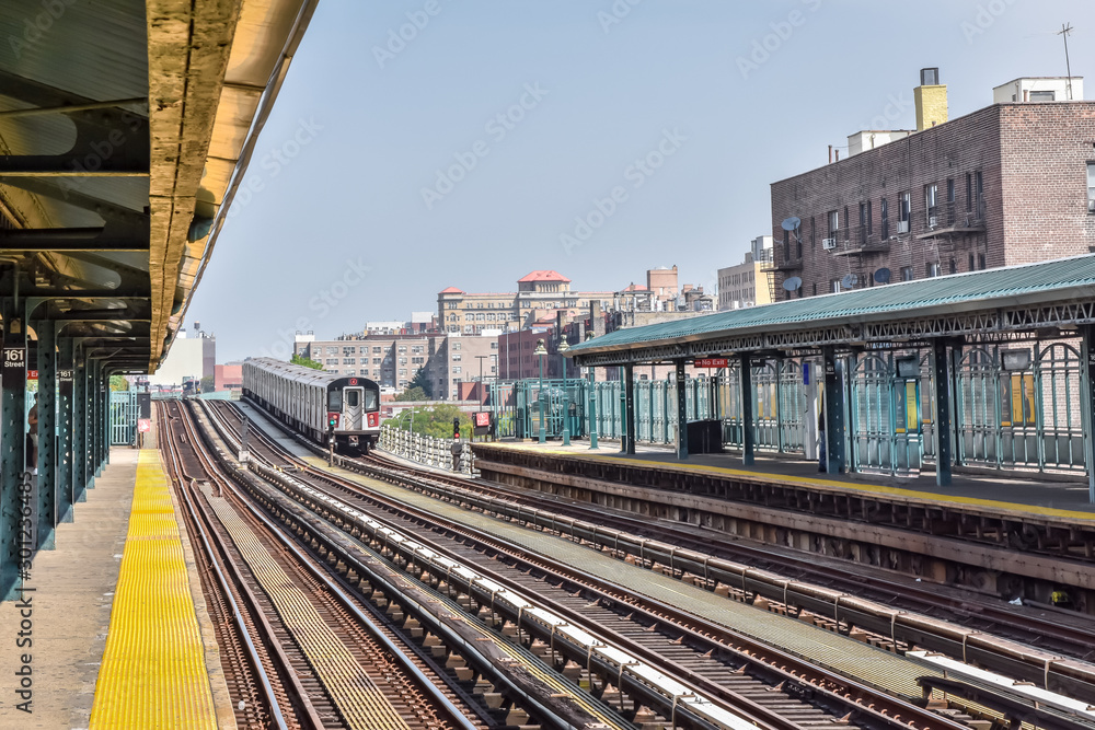 Train arriving at the station in New York City. Buildings in the background, cityscape. Travel and transit concept. Manhattan, NYC, USA