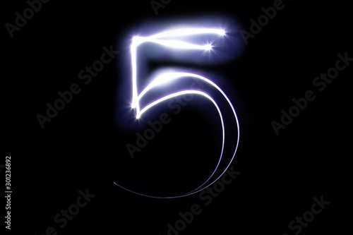 Set of numbers from neon light on a black background. Isolated top view, number 5.