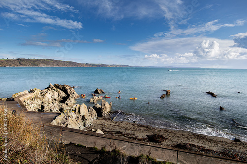 Kayaks in Looe Bay with fishing boat in clear winter sky photo