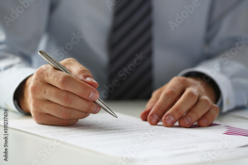 Hand of businessman in suit filling and signing with