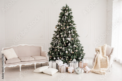 Classic christmas New Year decorated interior room New year tree. Christmas tree with gold decorations. Modern white classical style interior design