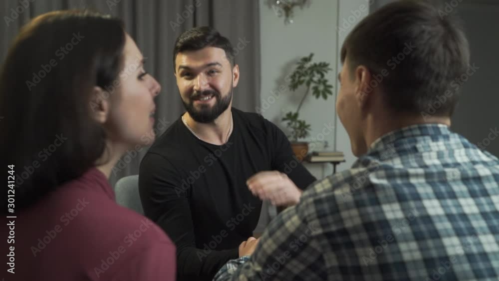 Young happy Caucasian family shaking psychologist's hand and smiling. Successful end of the couples therapy. Psychoanalysis, satisfied clients, professional help. Young happy Caucasian family shaking psychologist's hand and smiling. Successful end of the couples therapy. Psychoanalysis, satisfied clients, professional help.