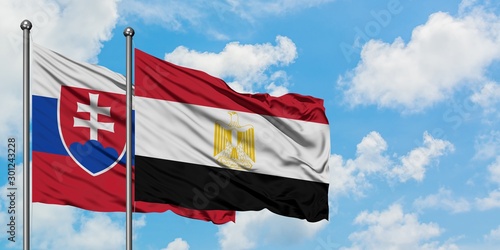 Canvas Print Slovakia and Egypt flag waving in the wind against white cloudy blue sky together