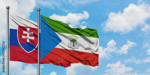 Photography Slovakia and Equatorial Guinea flag waving in the wind against white cloudy blue sky together