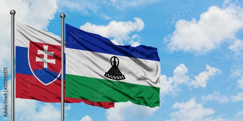 Canvas Print Slovakia and Lesotho flag waving in the wind against white cloudy blue sky together
