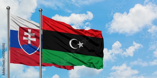 Canvas Print Slovakia and Libya flag waving in the wind against white cloudy blue sky together