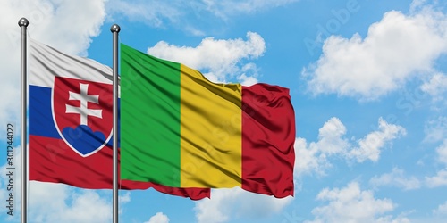 Photography Slovakia and Mali flag waving in the wind against white cloudy blue sky together
