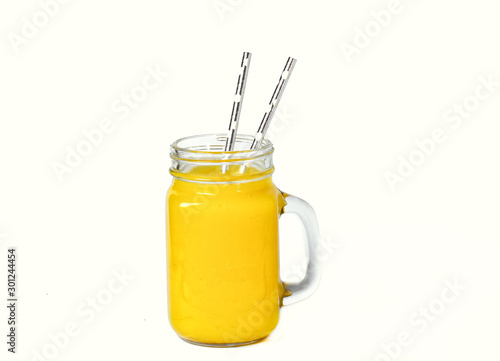 pineapple juice in a glass with a straw on a white background. Refreshing tasty healthy drink