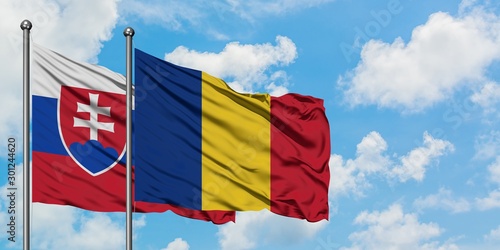 Canvas Print Slovakia and Romania flag waving in the wind against white cloudy blue sky together