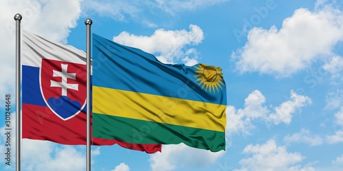 Canvas Print Slovakia and Rwanda flag waving in the wind against white cloudy blue sky together