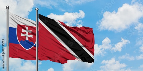Canvas Print Slovakia and Trinidad And Tobago flag waving in the wind against white cloudy blue sky together