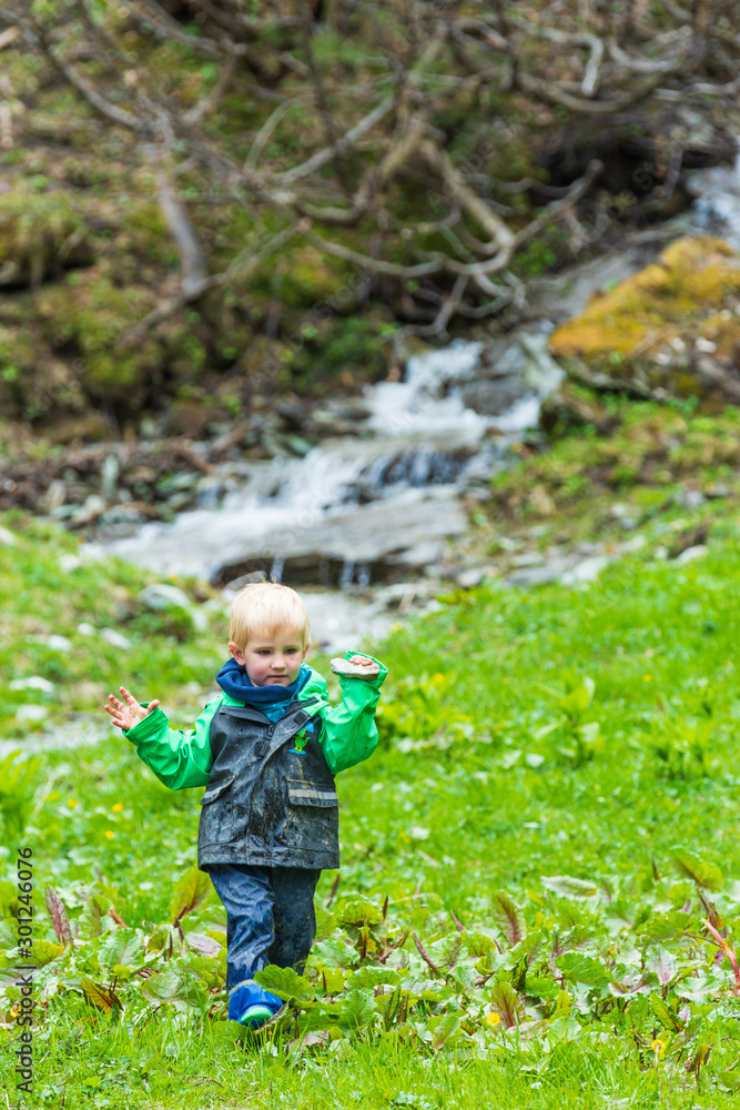 Junge, zwei Jahre, spielt am Wasser im Wald Junge, zwei Jahre, spielt am Wasser im Wald