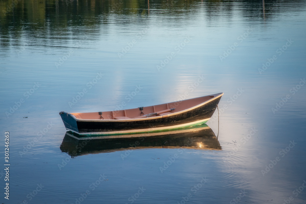 Wooden dinghy at mooring at dusk