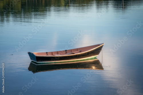 Wooden dinghy at mooring at dusk © John