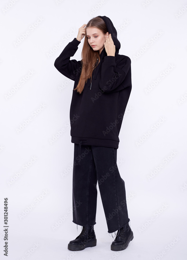 Young girl wearing blank and oversize black long hoody. White background Young girl wearing blank and oversize black long hoody. White background