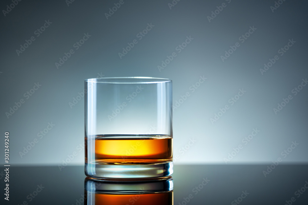 Elegant simple glass of luxury whisky against light background Elegant simple glass of luxury whisky against light background