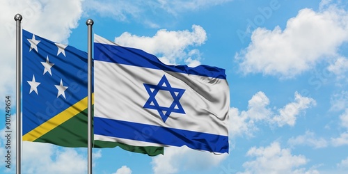 Solomon Islands and Israel flag waving in the wind against white cloudy blue sky together. Diplomacy concept, international relations.