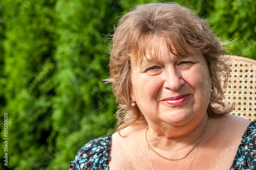 Mature woman in Park smiling and looking at camera
