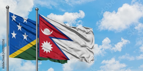 Solomon Islands and Nepal flag waving in the wind against white cloudy blue sky together. Diplomacy concept, international relations.