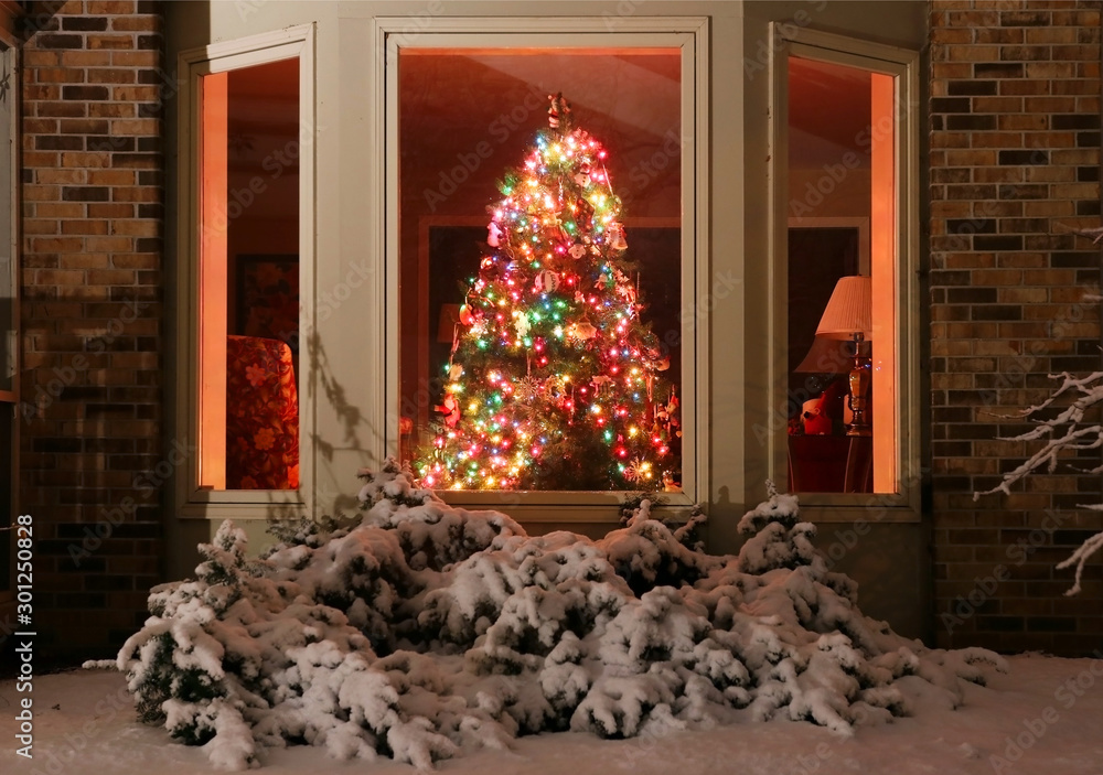 Christmas  scene with decorated Christmas tree glowing in a  dark room of the private