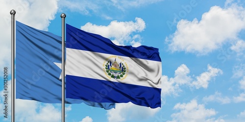 Somalia and El Salvador flag waving in the wind against white cloudy blue sky together. Diplomacy concept, international relations.