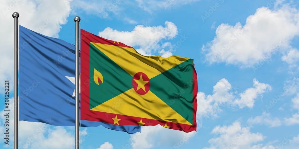 Somalia and Grenada flag waving in the wind against white cloudy blue sky together. Diplomacy concept, international relations. Somalia and Grenada flag waving in the wind against white cloudy blue sky together. Diplomacy concept, international relations.