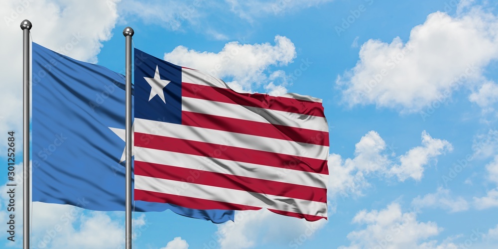 Somalia and Liberia flag waving in the wind against white cloudy blue sky together. Diplomacy concept, international relations. Somalia and Liberia flag waving in the wind against white cloudy blue sky together. Diplomacy concept, international relations.