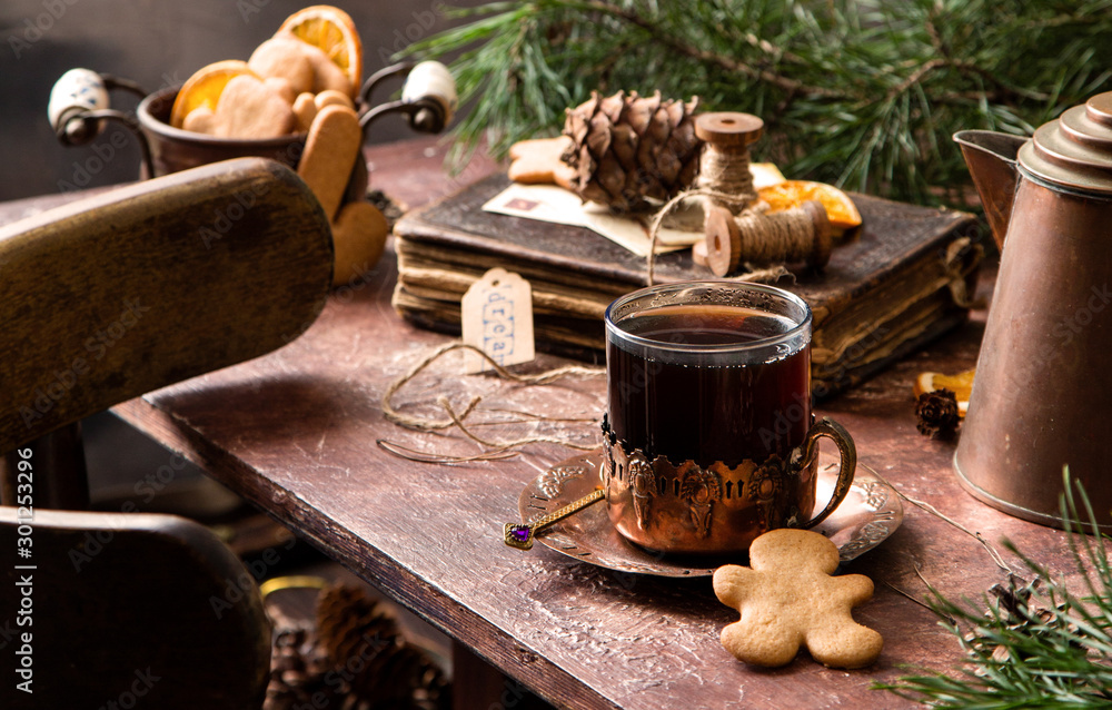 christmas coffee in glass cup on copper cup holder on rustic wooden table with gingerbread cookies